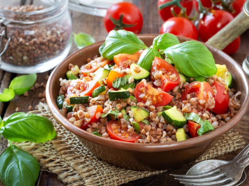 Buchweizensalat mit Zucchini und Tomaten in einer SchÃ¼ssel.