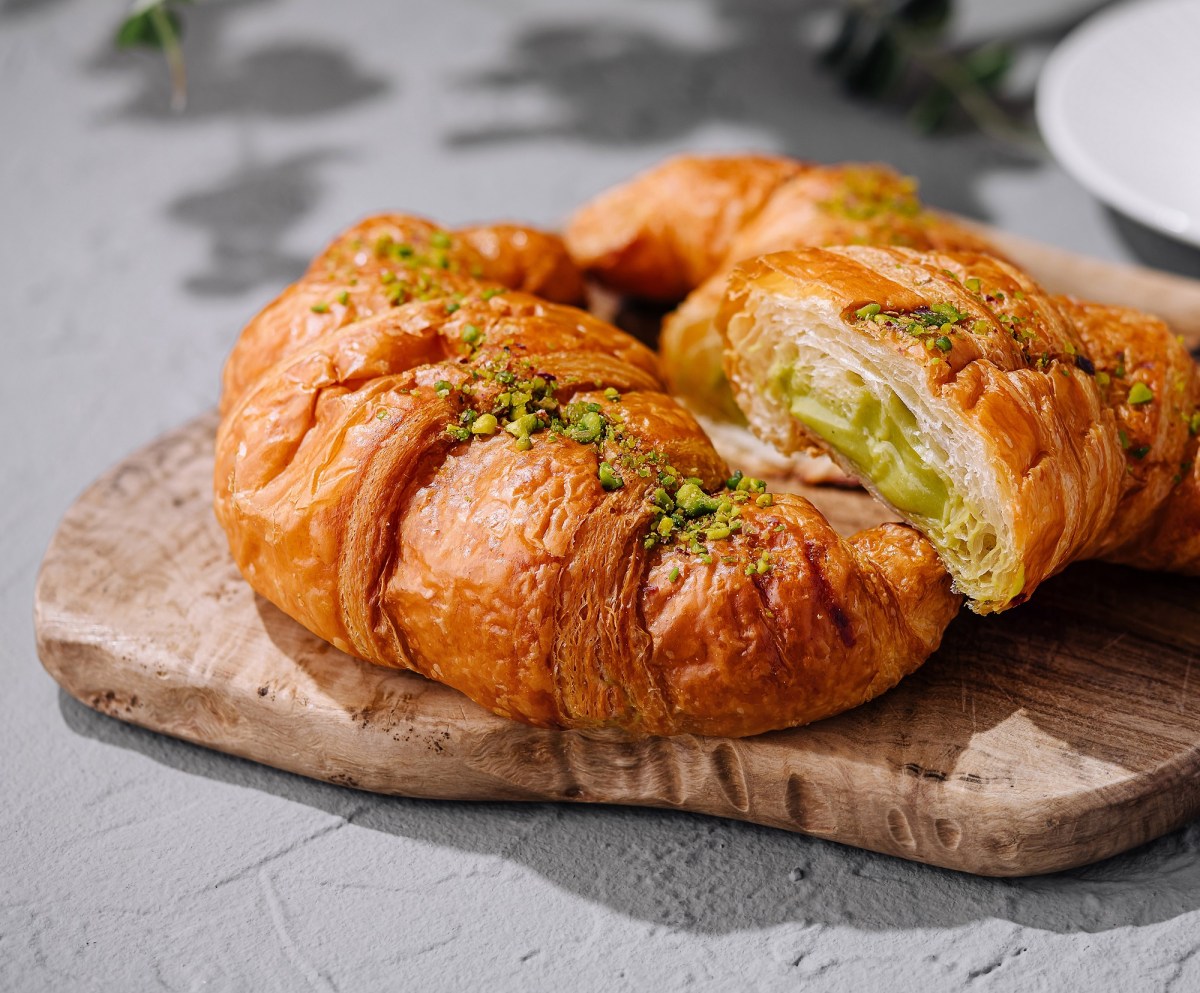 Schnelle Pistazien-Croissants auf einem Brett, bestreut mit Pistazien.