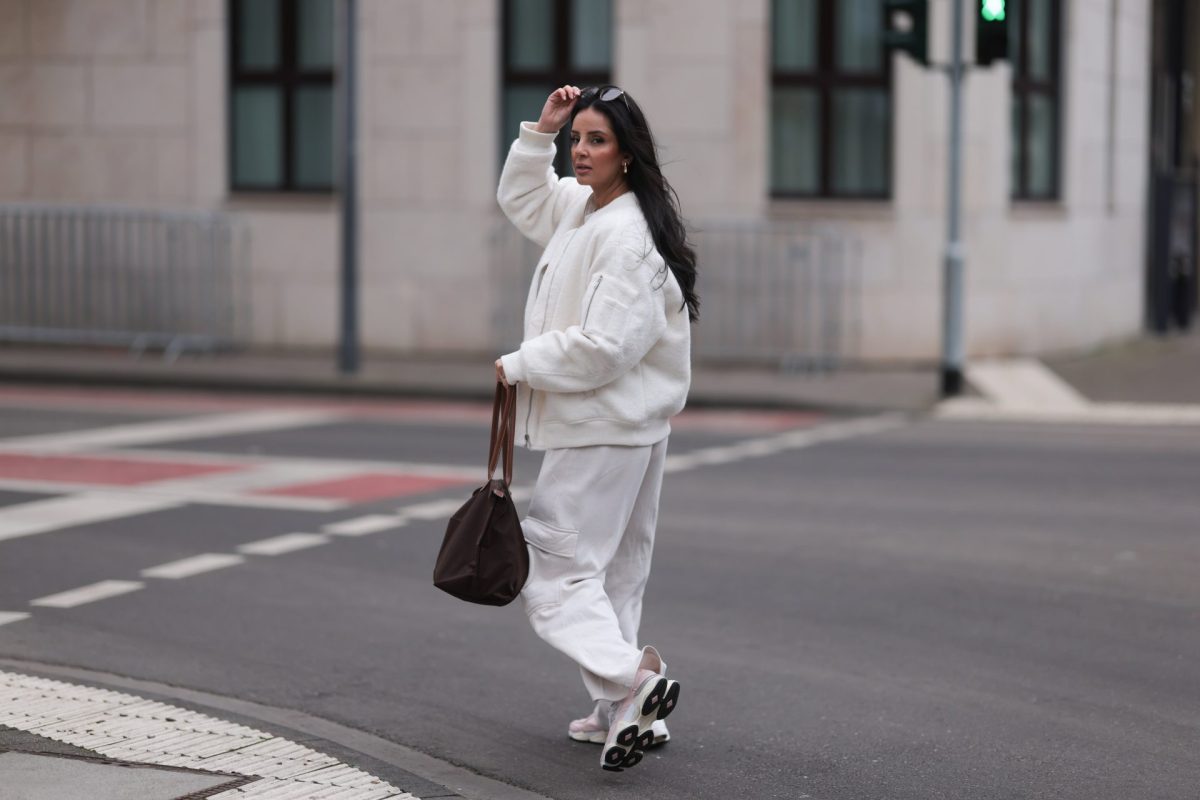 Frau im weiÃŸen Outfit mit Sneakern