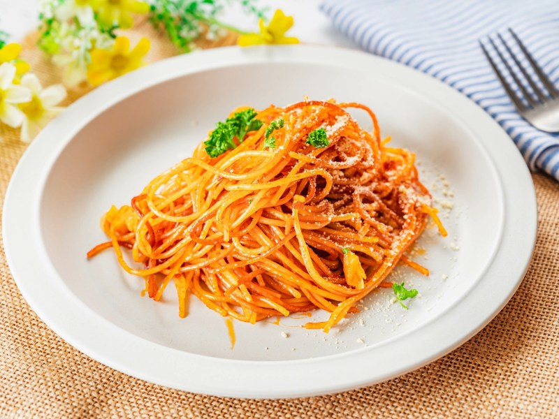 Spaghetti all'Assassina auf einem weiÃŸen Teller, daneben liegt eine Gabel.