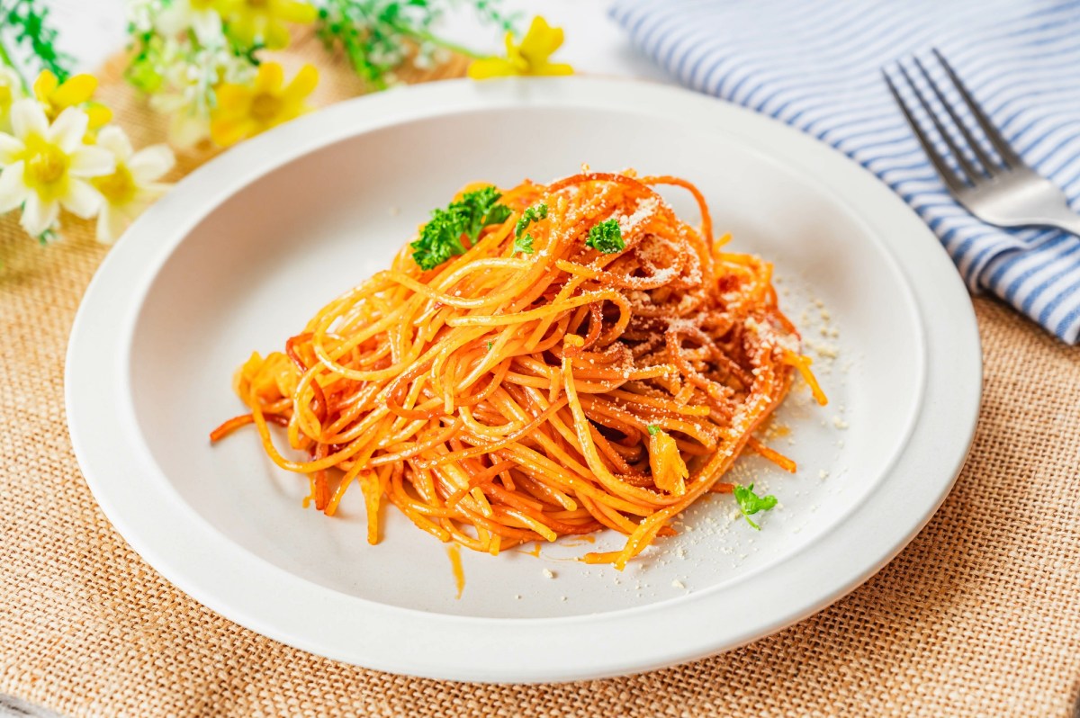 Spaghetti all'Assassina auf einem weiÃŸen Teller, daneben liegt eine Gabel.