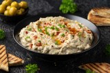 Baba Ganoush in einer schwarzen Schale mit OlivenÃ¶l und Petersilie dekoriert