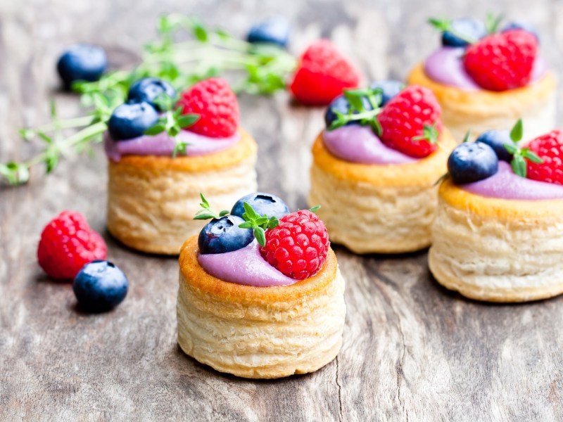 BlÃ¤tterteig-Pasteten mit Beeren auf einem Tisch.