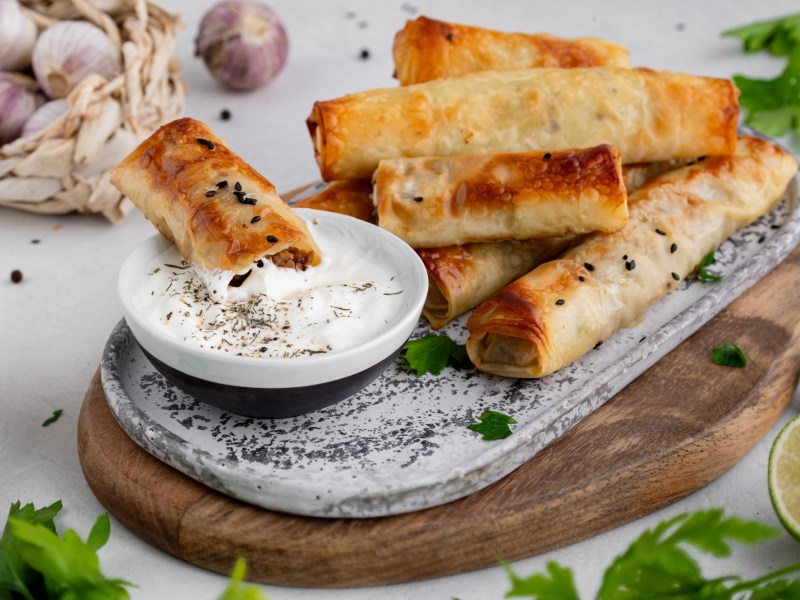 Feta-RÃ¶llchen auf einem Tablett mit Dip.