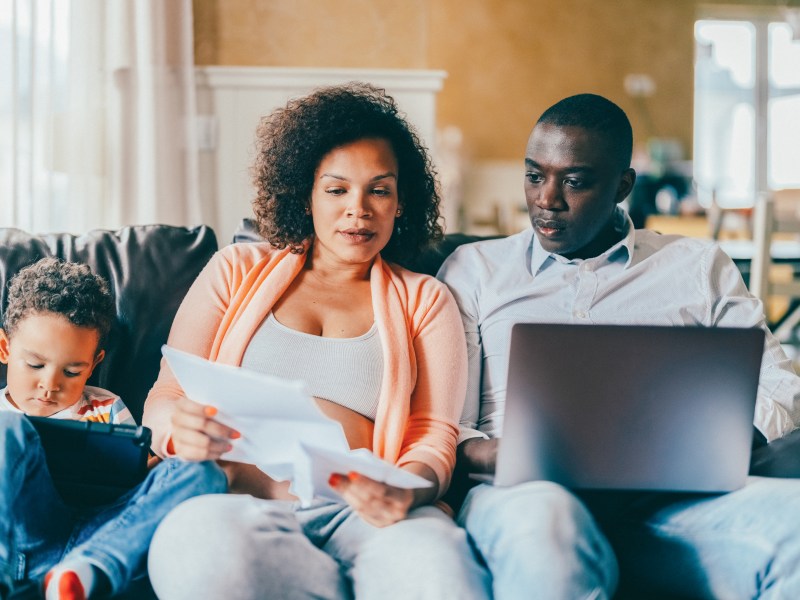 Familie zu Hause analysiert Dokumente.