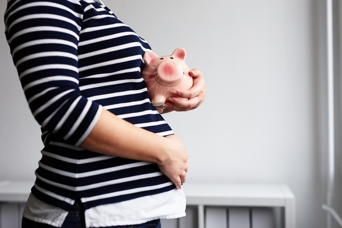 Kindergeld: Schwangere Frau mit Sparschwein in der Hand.