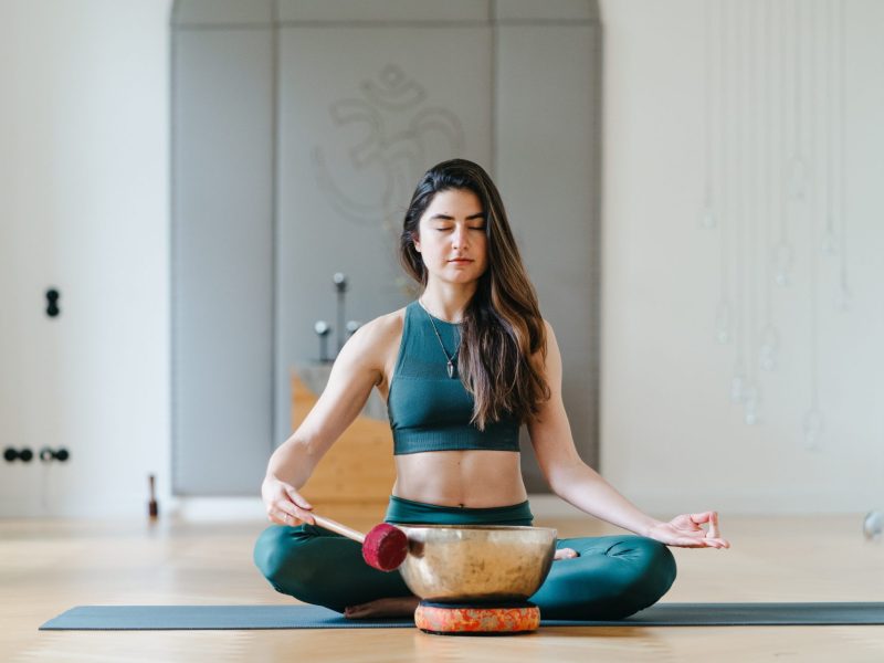 Frau macht Klangschalenmeditation