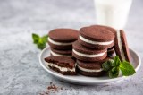 Ein Teller selbst gemachte Oreos mit einem Glas Milch im Hintergrund.