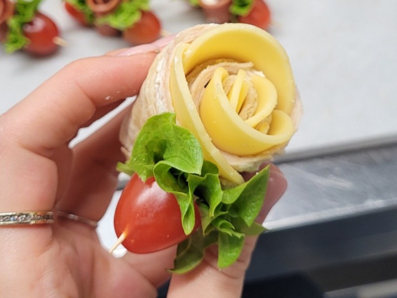 Eine Frau hÃ¤lt eine Tortilla-Rose in der Hand.