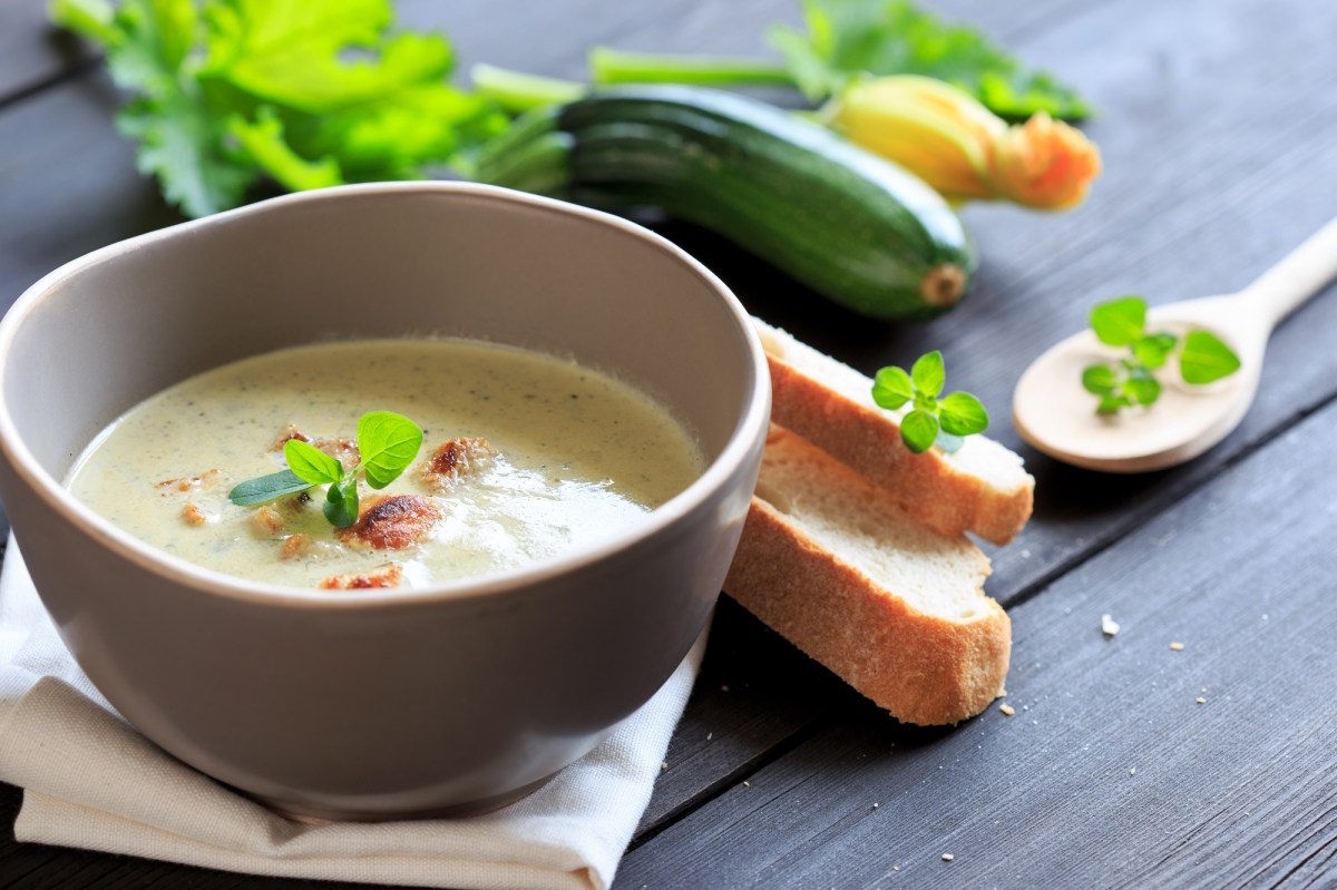 Schale mit Zucchini-Kokos-Suppe und GemÃ¼se daneben