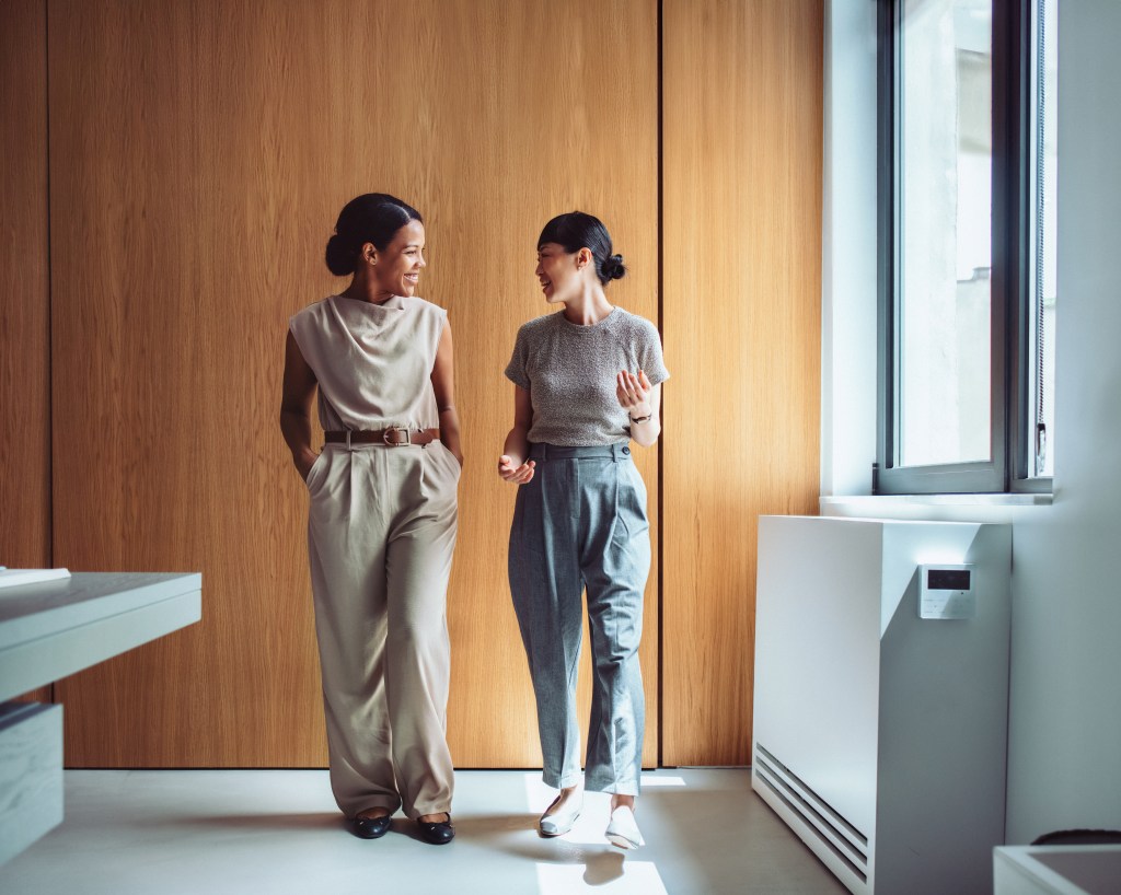 Zwei Frauen unterhalten sich im Büro.